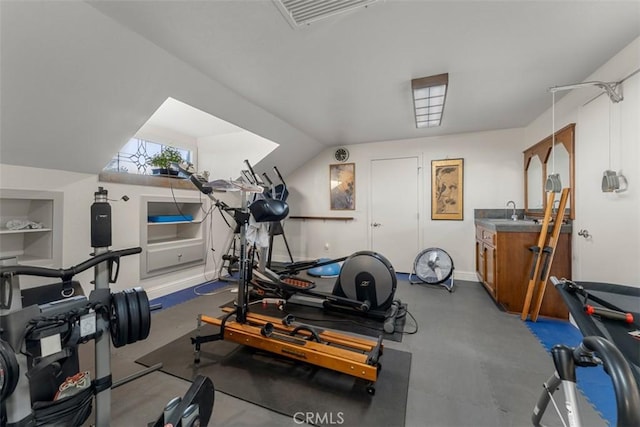 workout area featuring lofted ceiling, built in features, and sink