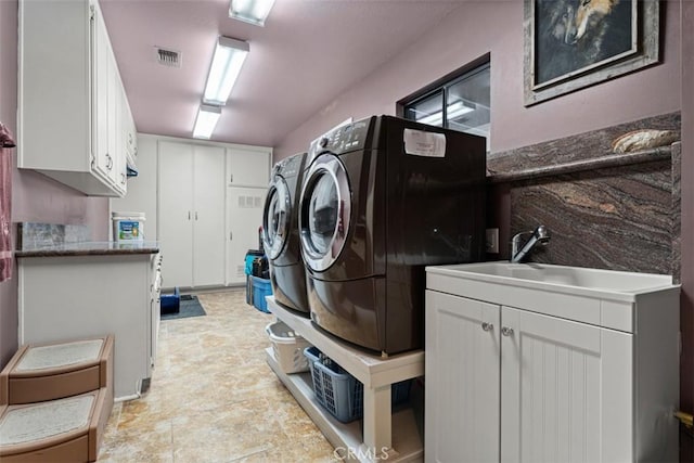 clothes washing area with cabinets, separate washer and dryer, and sink