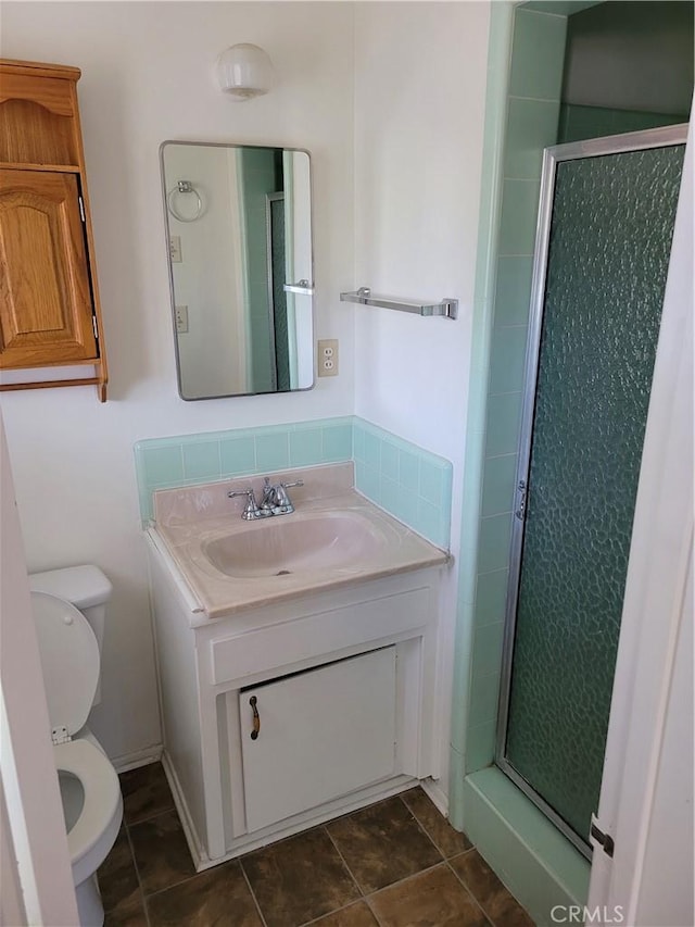 bathroom featuring toilet, walk in shower, and vanity