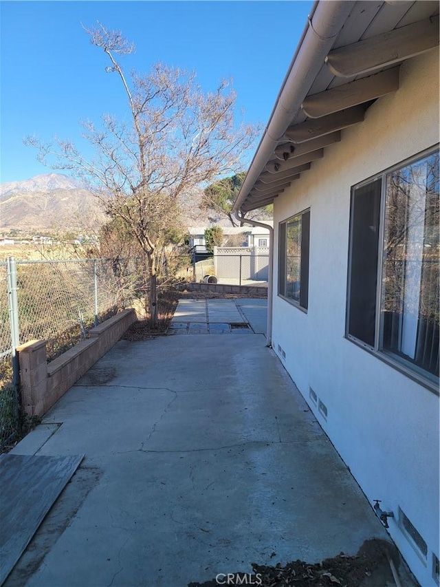 view of side of property featuring a mountain view and a patio area