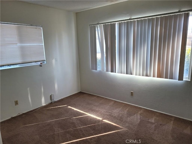 spare room with dark colored carpet