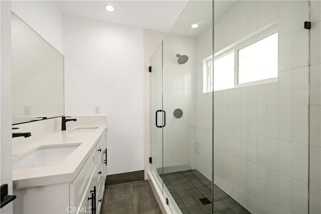 bathroom with a shower with shower door and vanity