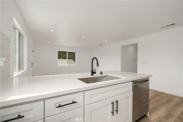 kitchen featuring sink, white cabinetry, stainless steel dishwasher, and a wealth of natural light