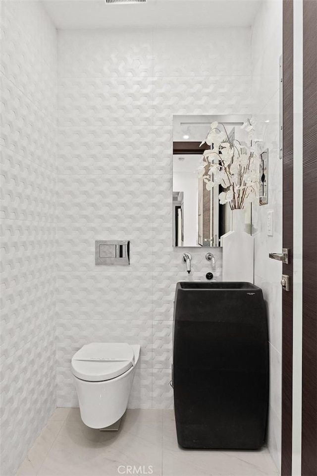 bathroom with toilet and tile patterned flooring