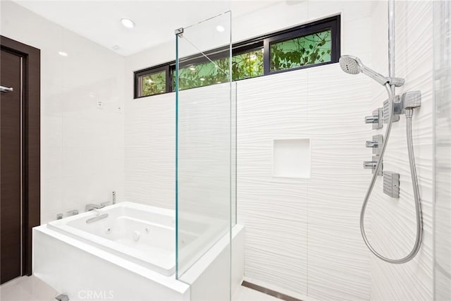 bathroom with tile walls and separate shower and tub