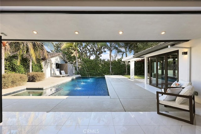 view of swimming pool featuring pool water feature and a patio