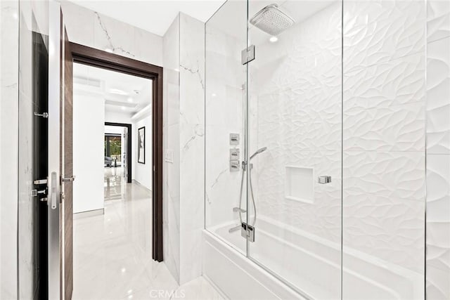 bathroom with tile walls and combined bath / shower with glass door