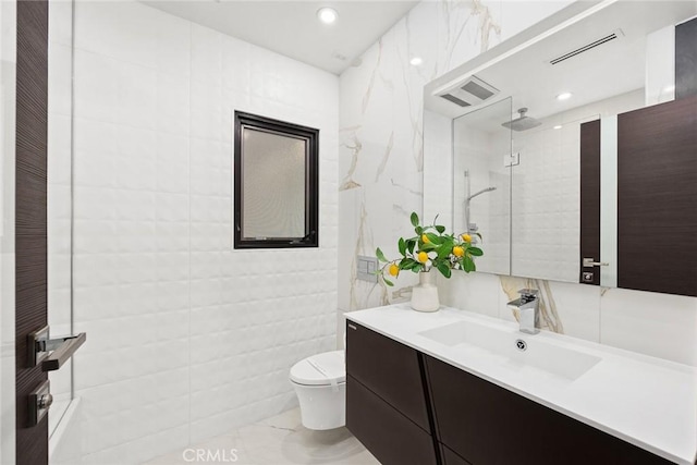 bathroom with toilet, vanity, tile walls, and tiled shower