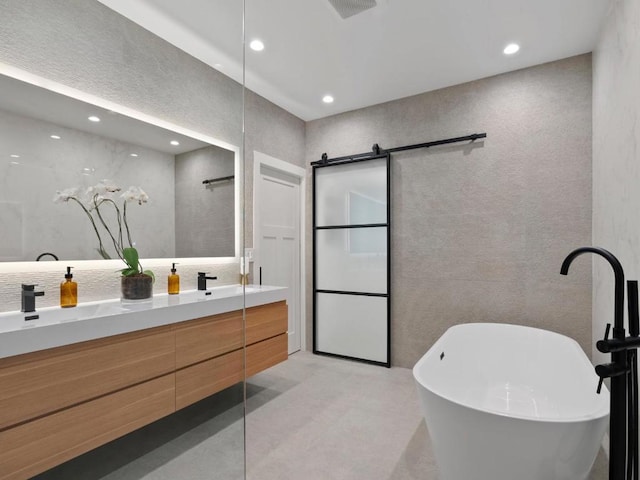 bathroom with a washtub and vanity