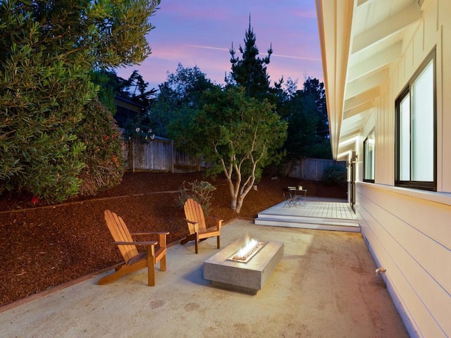 patio terrace at dusk featuring an outdoor fire pit