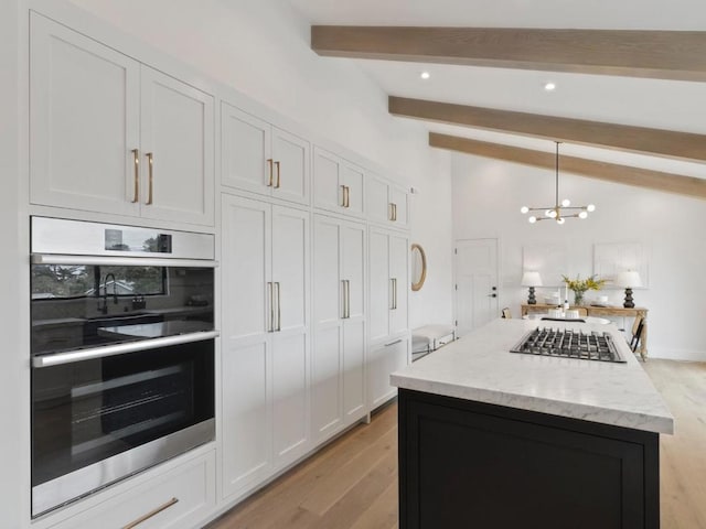 kitchen with decorative light fixtures, a kitchen island, vaulted ceiling with beams, white cabinetry, and appliances with stainless steel finishes