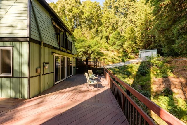 wooden deck featuring a garage and an outdoor structure