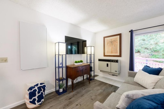 living room featuring heating unit, a textured ceiling, and hardwood / wood-style floors