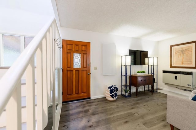 foyer entrance featuring a textured ceiling and dark hardwood / wood-style flooring