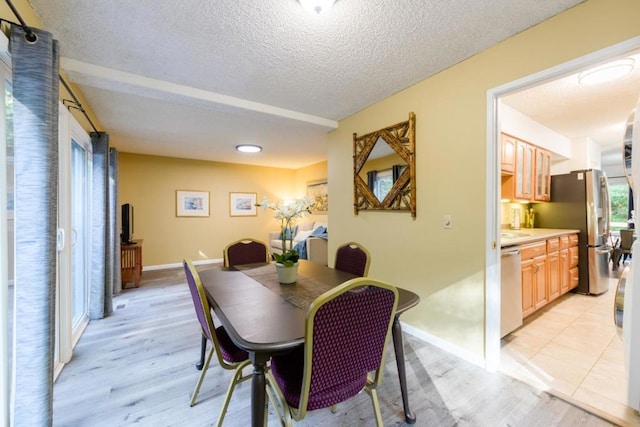 dining room with a textured ceiling and light hardwood / wood-style floors