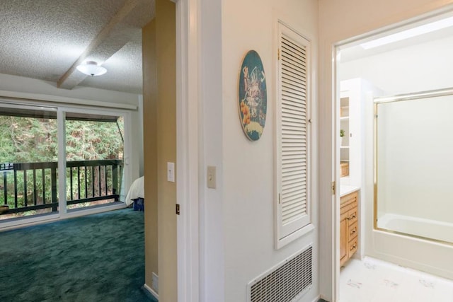 hallway with carpet and a textured ceiling