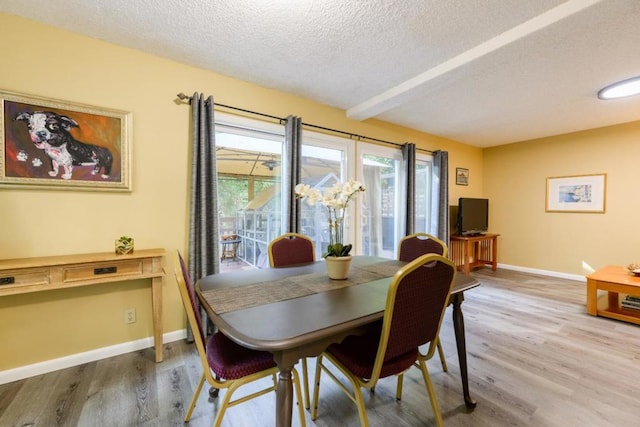 dining room featuring a textured ceiling and wood-type flooring