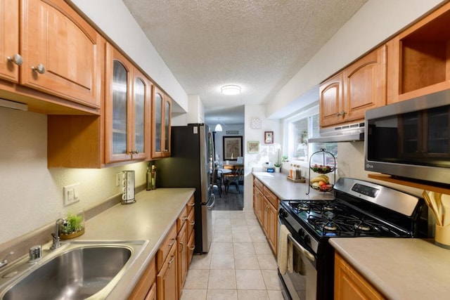 kitchen featuring sink, a textured ceiling, appliances with stainless steel finishes, and light tile patterned flooring