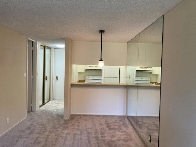 kitchen featuring white cabinetry, decorative light fixtures, a textured ceiling, carpet floors, and white appliances