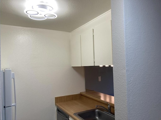 kitchen with sink, dishwasher, white cabinets, and white fridge