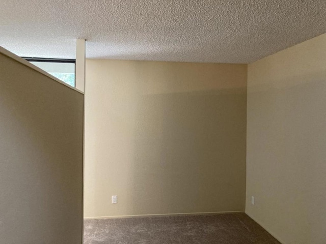 carpeted empty room with a textured ceiling