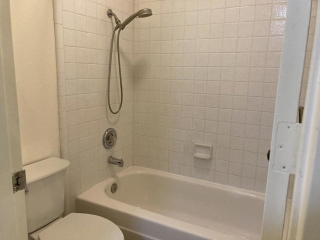 bathroom featuring tiled shower / bath and toilet