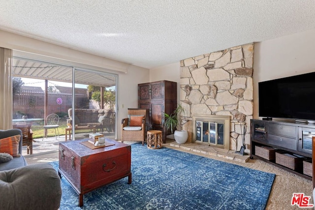 living room featuring a stone fireplace and a textured ceiling