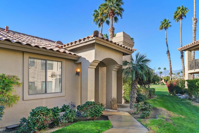 view of exterior entry with a lawn