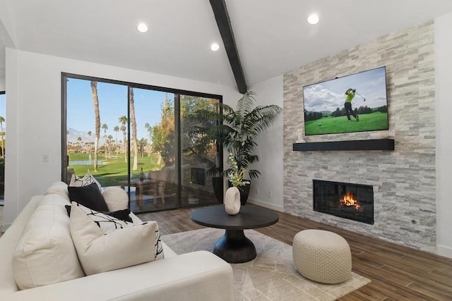 living room featuring a stone fireplace, lofted ceiling with beams, and hardwood / wood-style flooring