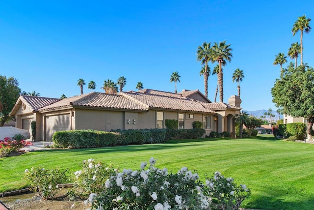 view of front of property with a garage and a front lawn