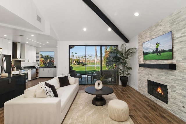 living room featuring dark wood-type flooring, a fireplace, lofted ceiling with beams, and a wealth of natural light