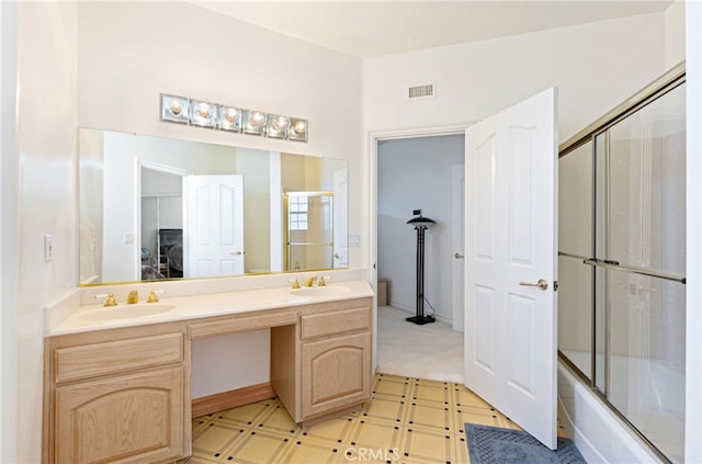 bathroom featuring vanity and shower / bath combination with glass door