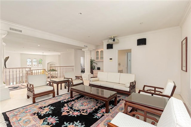 living room with crown molding and decorative columns