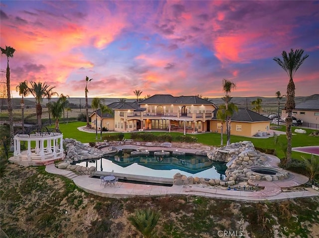 pool at dusk featuring a yard and a patio