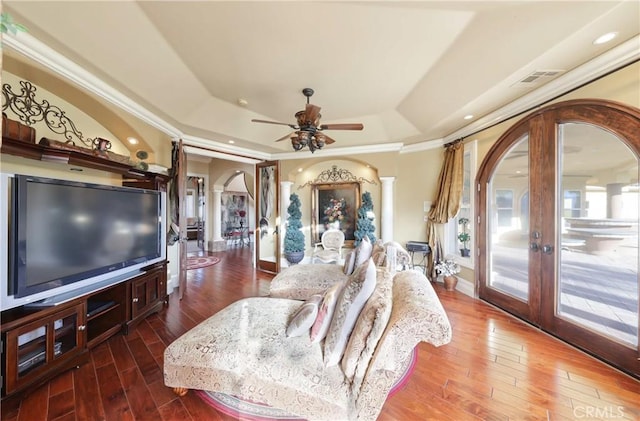 living room with hardwood / wood-style floors, ornate columns, french doors, ceiling fan, and a tray ceiling