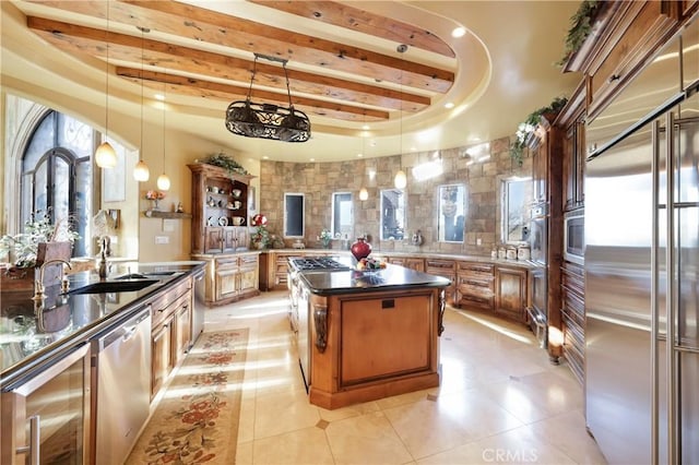 kitchen with pendant lighting, kitchen peninsula, light tile patterned flooring, beamed ceiling, and stainless steel appliances