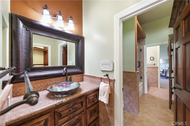 bathroom with tile walls, vanity, and tile patterned flooring