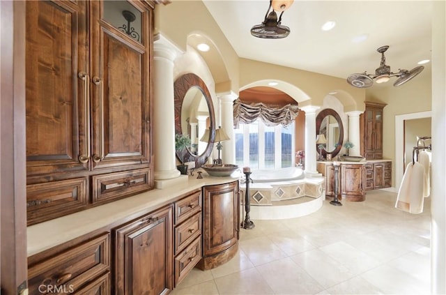 bathroom featuring tiled bath, vanity, ceiling fan, tile patterned flooring, and ornate columns