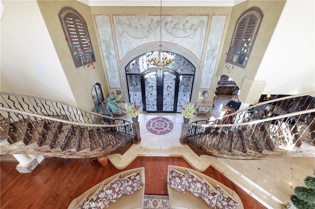 foyer entrance featuring hardwood / wood-style flooring, french doors, and a notable chandelier