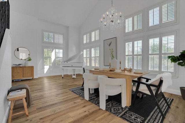 dining room with hardwood / wood-style flooring, a high ceiling, and an inviting chandelier