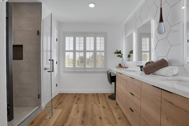 bathroom featuring vanity, wood-type flooring, and a shower with door