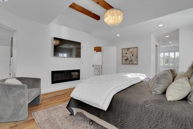 bedroom with an inviting chandelier and light hardwood / wood-style floors