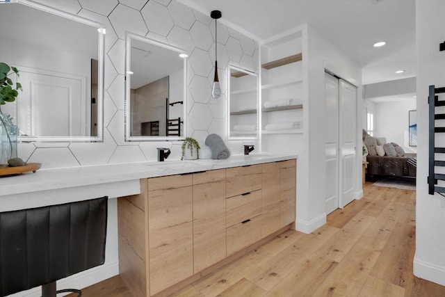 bathroom featuring vanity, hardwood / wood-style flooring, and decorative backsplash