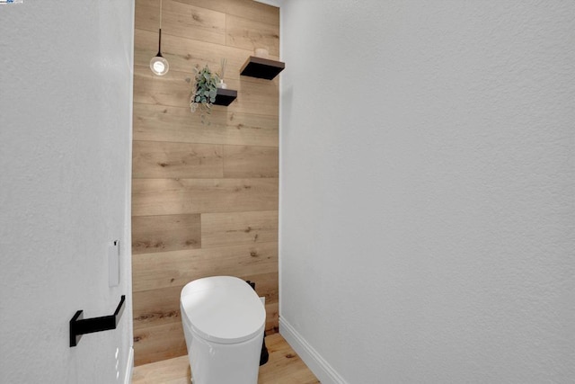 bathroom with wood-type flooring and wood walls