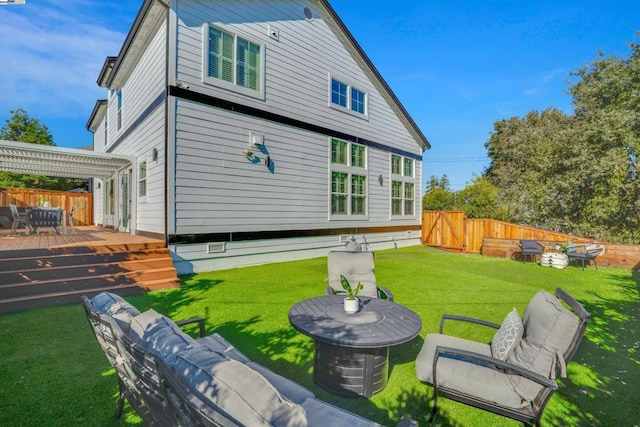 back of house featuring a wooden deck, a pergola, and a lawn