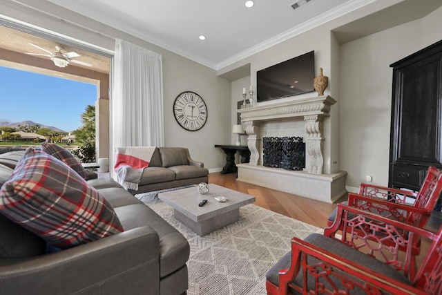 living room featuring ceiling fan, crown molding, and wood-type flooring