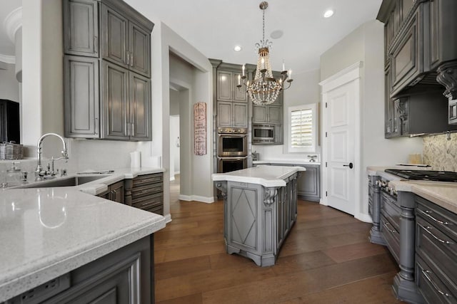 kitchen with stainless steel appliances, decorative backsplash, a kitchen island, pendant lighting, and sink