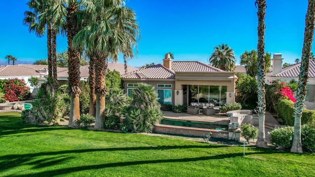 back of property with an outdoor hangout area, a patio area, and a lawn