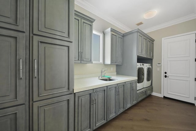 washroom with dark hardwood / wood-style floors, separate washer and dryer, cabinets, crown molding, and sink