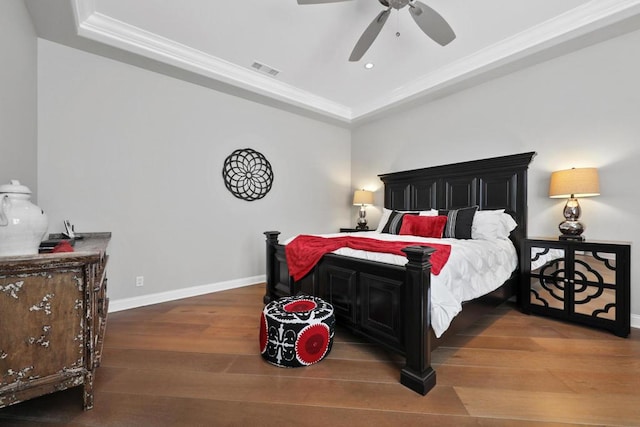 bedroom with ceiling fan, crown molding, a tray ceiling, and hardwood / wood-style flooring